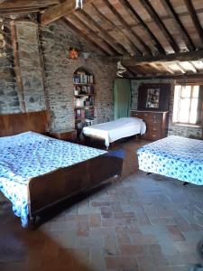 1 dormitorio con 2 camas y pared de piedra en Attic with balcony at Locanda del Capo, en Capannori