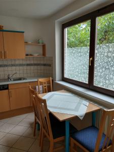 cocina con mesa, sillas y ventana en Ferienwohnung Madlene 2, en Gablitz