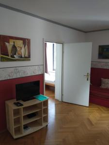 a living room with a door and a television on a cabinet at Ferienwohnung Madlene 2 in Gablitz
