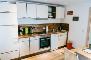 a kitchen with white appliances and a wooden table at Ferienwohnung Klink in Lieser