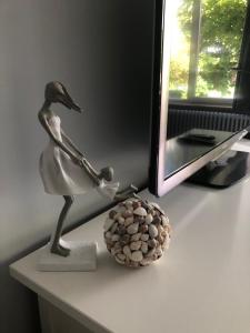 een standbeeld van een vrouw die op een tafel naast een spiegel staat bij Spacious studio in Knokke-Heist