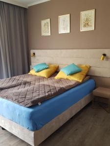 ein Bett mit blauen und gelben Kissen in einem Schlafzimmer in der Unterkunft APARTAMENT "ADELL" - MIĘDZYZDROJE, Bella Mare Aqua 1 in Misdroy