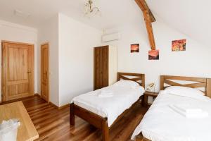 Habitación con 2 camas, paredes blancas y suelo de madera. en CHIC VOYAGE, en Sibiu