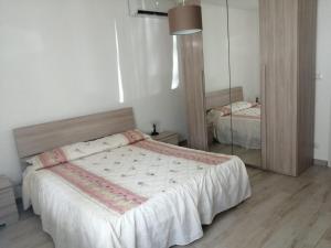una camera con un grande letto e uno specchio di Recanati taormina beach a Giardini Naxos