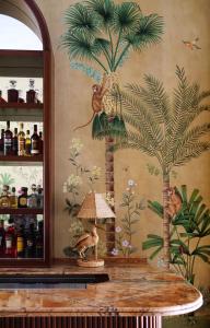 a painting of palm trees and a table with a lamp at Albergo Hotel in Beirut