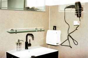 a bathroom with a sink and a camera on the wall at Liva Apartments Herne in Herne +26 photos