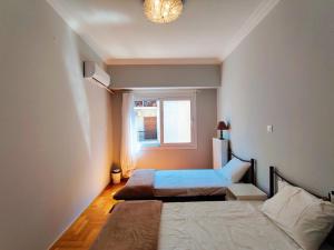 - une chambre avec 2 lits et une fenêtre dans l'établissement WSD Brand Cozy 2BD with Balcony near Acropolis, à Athènes