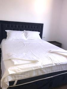 a white bed with a black headboard and white sheets at Casa Moonlight 2 Mai in 2 Mai