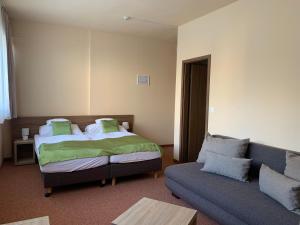salon z łóżkiem i kanapą w obiekcie Centrooms Eger w Egerze