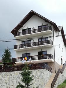 un edificio bianco con balconi e bandiera di Sport Avalanche a Ranca