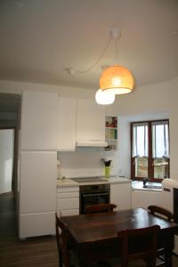 a kitchen with a wooden table and aendant light at nel cuore di Bormio in Bormio +10 photos
