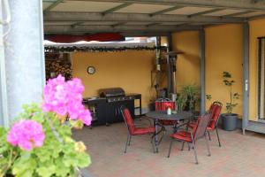 eine Terrasse mit einem Tisch, Stühlen und einem Herd in der Unterkunft Kleines Zuhause in Magdeburg