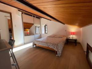 una camera con letto e soffitto in legno di Le Gîte De Babeth a Saint-Maurice-dʼIbie
