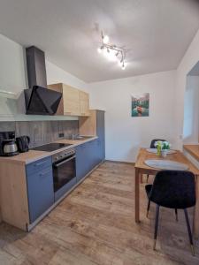 cocina con armarios azules y mesa de madera en Ferienwohnung Kramerhof, en Ebbs