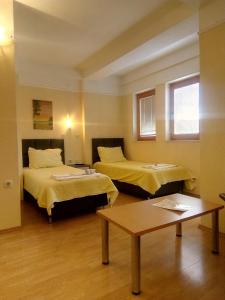 a hotel room with two beds and a table at Villa Rimari in Ohrid