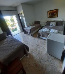 - une chambre avec deux lits et un canapé dans l'établissement Pousada Guinda DIAMANTINA -MG, à Diamantina