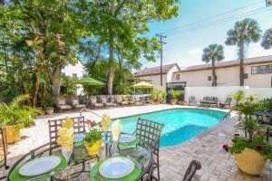 a patio with a table and chairs next to a swimming pool at The Kenwood Inn Oldest Bed and Breakfast, St Augustine Historic District in St. Augustine