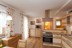 een keuken met witte muren, houten kasten en een fornuis bij Gut Mitterlehen in Elsbethen