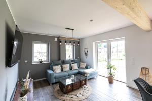 a living room with a blue couch and a table at Ferienhaus Heuliebe in Herbstein