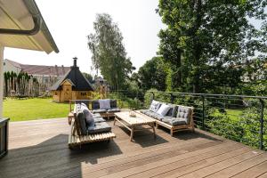 a patio with two couches and a table on a deck at Ferienhaus Heuliebe in Herbstein