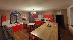 une cuisine avec des placards rouges et une table en bois dans l'établissement GITE LONGERE DE 15 PERSONNES AU CHATEAU DE JALLANGES VOUVRAY, à Vernou-sur-Brenne