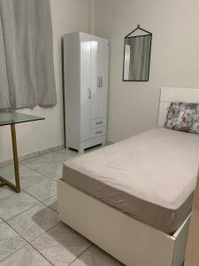 um quarto branco com uma cama e uma cómoda em Apartamento bem localizado próximo ao DETRAN, Assembleia Legislativa de Cuiabá, Centro Político e Shopping Pantanal em Cuiabá