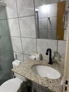 uma casa de banho com um lavatório, um WC e um espelho. em Apartamento bem localizado próximo ao DETRAN, Assembleia Legislativa de Cuiabá, Centro Político e Shopping Pantanal em Cuiabá