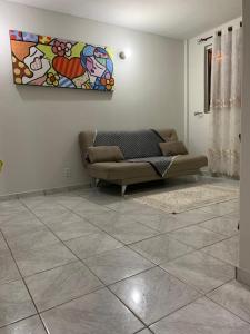 uma sala de estar com um sofá e uma pintura na parede em Apartamento bem localizado próximo ao DETRAN, Assembleia Legislativa de Cuiabá, Centro Político e Shopping Pantanal em Cuiabá