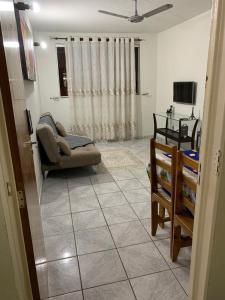 uma sala de estar com um sofá e uma televisão em Apartamento bem localizado próximo ao DETRAN, Assembleia Legislativa de Cuiabá, Centro Político e Shopping Pantanal em Cuiabá