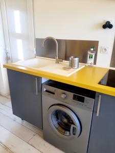 a kitchen with a sink and a washing machine at Le Paddle - station balnéaire Les Sablettes in La Seyne-sur-Mer