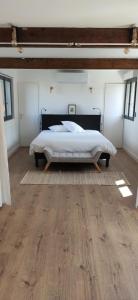 a bedroom with a bed and a wooden floor at Le Pigeonnier Spa du Panty Gîte rural de charme in Saint-Tricat