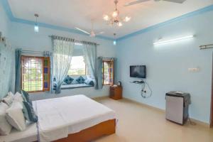 Dormitorio azul con cama y TV en Devendragarh Palace - Luxury Paying Guest House, en Udaipur