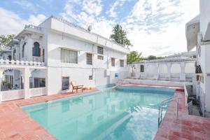 ウダイプールにあるDevendragarh - A Boutique Lake Facing Guest House On Lake Fateh Sagarの大きな白い家(スイミングプール付)