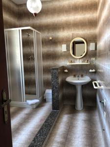 y baño con ducha, lavabo y espejo. en Appartamenti Vista Mare, en Nicotera
