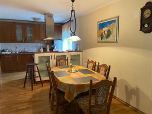 una cucina e una sala da pranzo con tavolo e sedie di Apartment Tody's a Fužine