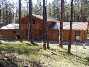 uma cabana na floresta com um grupo de árvores em Comanche Lodge em Custer