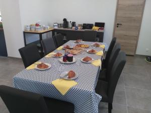 a table with plates of food on top of it at Les Chambres d Odile in Lachapelle-sous-Chaux