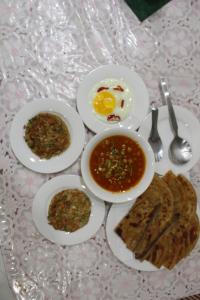 einen Tisch mit Teller mit Speisen, Eiern und Brot in der Unterkunft HOTEL STATE RESIDENCY in Bahawalpur