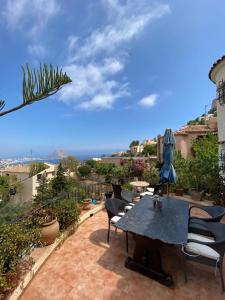 Una mesa y sillas en un patio con vista al mar. en Laura Las Flores, en Calpe 20 fotos más
