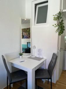 ein Büro mit einem Schreibtisch mit 2 Stühlen und einem Spiegel in der Unterkunft Apartment in der Innenstadt in Göttingen