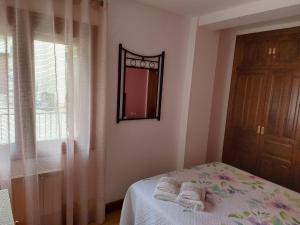 a bedroom with a bed and a mirror and a window at Los Llanos de Escarrilla in Escarrilla