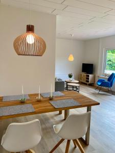 een woonkamer met een houten tafel en stoelen bij Ferienhaus an der Seefahrtschule in Großefehn 