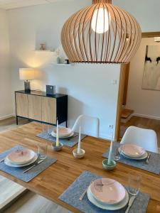 a dining room table with plates and candles on it at Ferienhaus an der Seefahrtschule in Großefehn 