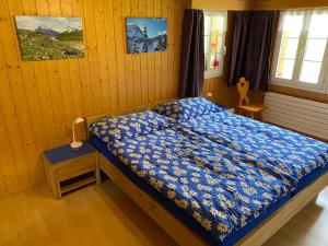 a bedroom with a bed with a blue comforter at Chalet Herrschaft in Grindelwald