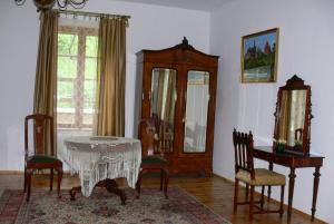 a dining room with a table and chairs and a mirror at Dworek Karpińskich in Sandomierz