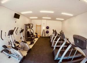 a gym with several treadmills and cardio machines at Apartamento - Itaipava in Itaipava