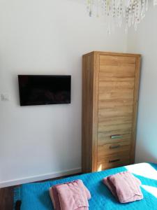 a bedroom with a bed and a dresser with two towels at Lipowa 22 Centrum Apartament in Białystok