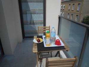 una mesa con una bandeja de fruta y bebidas en el balcón en Résidence l'estrade, en Dunkerque