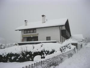 a house covered in snow with a fence at Apart Pöll in Ried im Oberinntal
