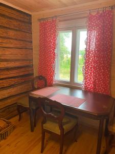 comedor con mesa y ventana en Private Hiiumaa Cottage plus Sauna and new indoor bathroom, en Lelu